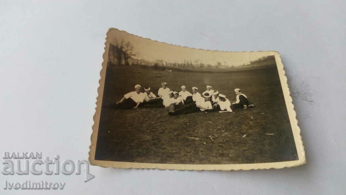 Photo Young people with heroic hats lying on the lawn