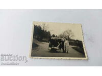 Φωτογραφία Ένας άνδρας και τέσσερις γυναίκες με ένα ρετρό καρότσι στο πάρκο