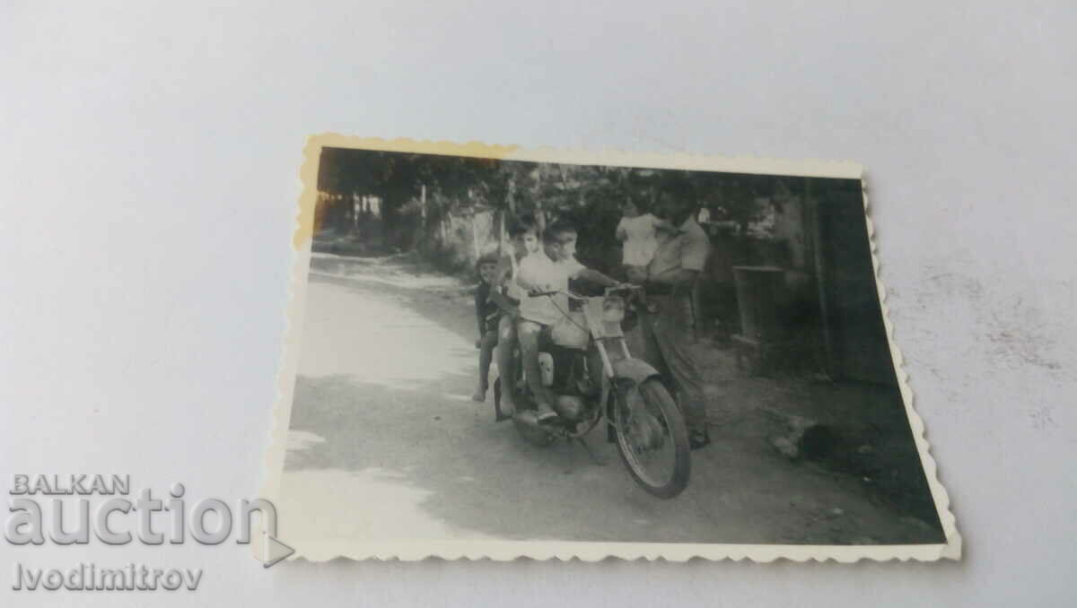Photo Children with a retro motorcycle on the street
