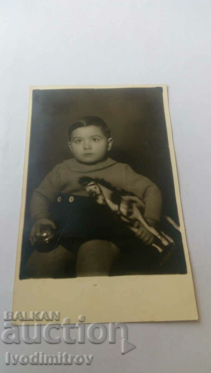 Photo Little boy with a bell and a toy horse