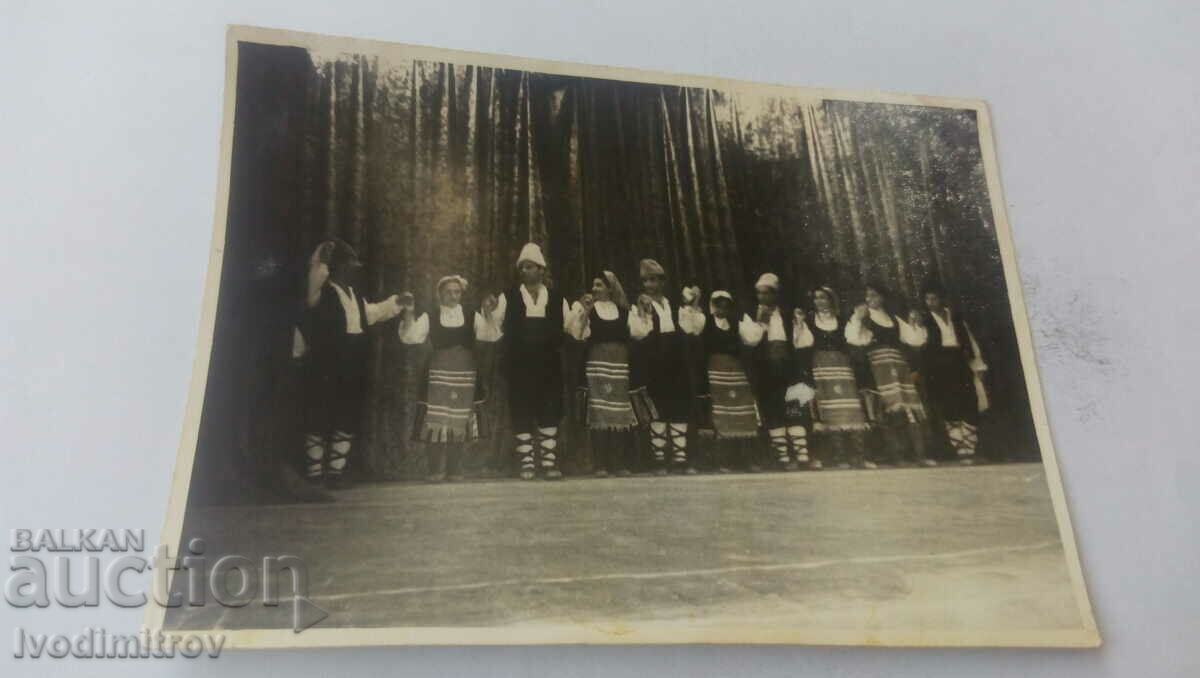 Φωτογραφία Άνδρες και γυναίκες με παραδοσιακές φορεσιές πιασμένοι χέρι χέρι