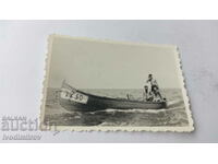 Photo Three young men with a boat 22 50 in the sea