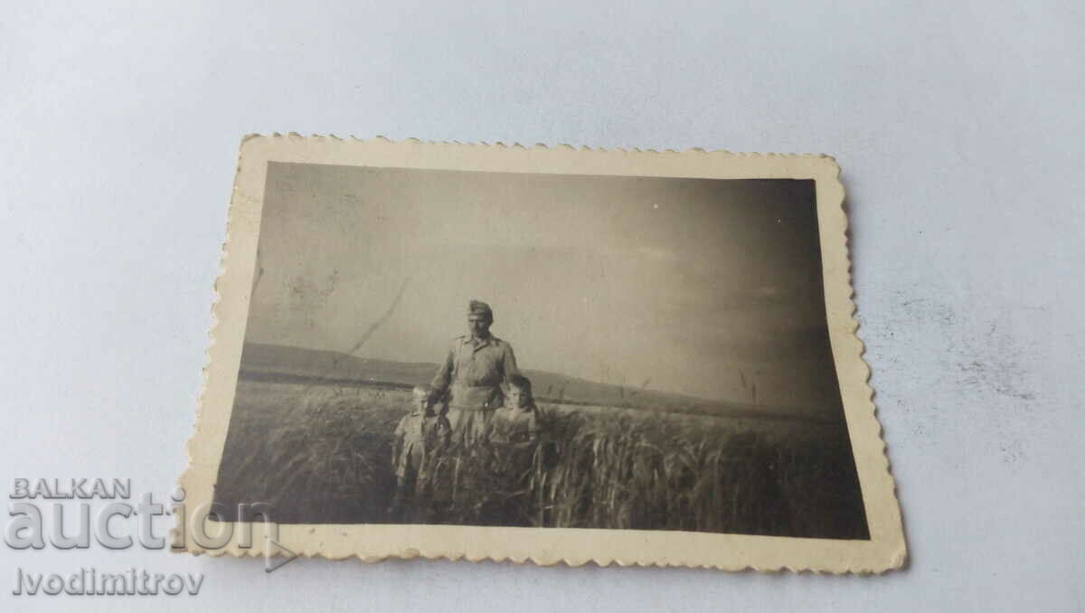 Photo Soldier with two boys in the grass