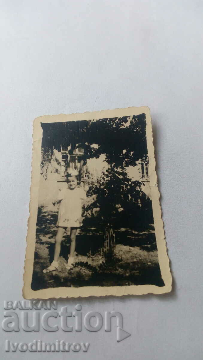 Снимка Момиченце с бяла рокличка в двора