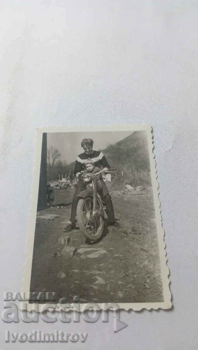 Fotografie Bărbat și băiețel pe o motocicletă retro