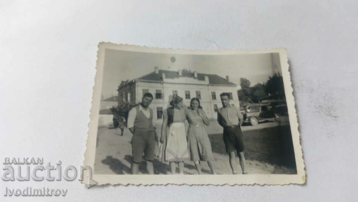 Photo Two men and two women in the village square