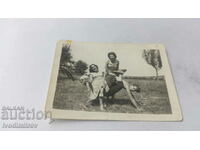 Photo Two girls and two girls with a figure on the lawn