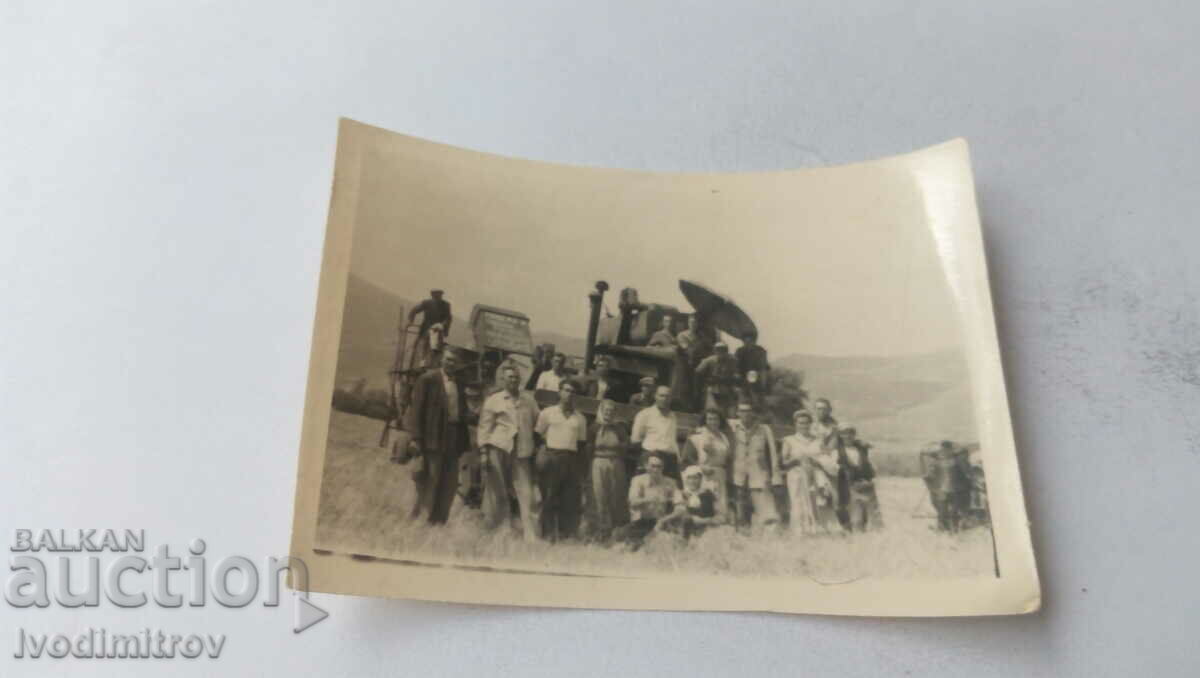 Снимка Мъже и жени пред ретро комбайн на нивата