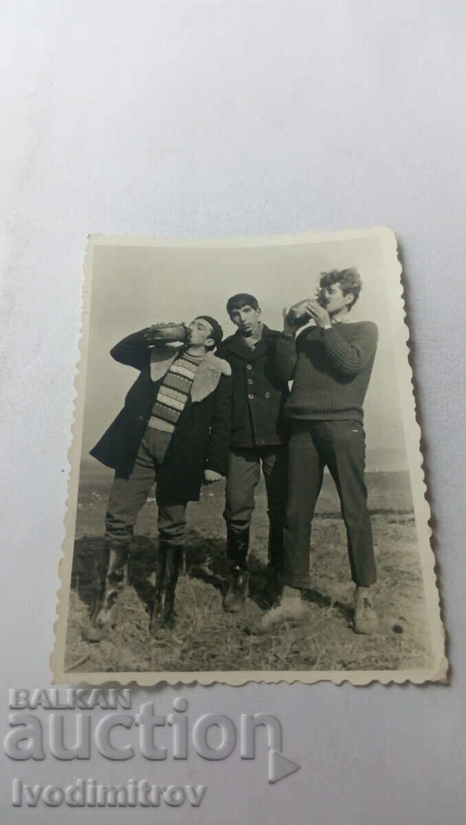 Φωτογραφία Τρεις νεαροί άνδρες με ξύλινα κύπελλα