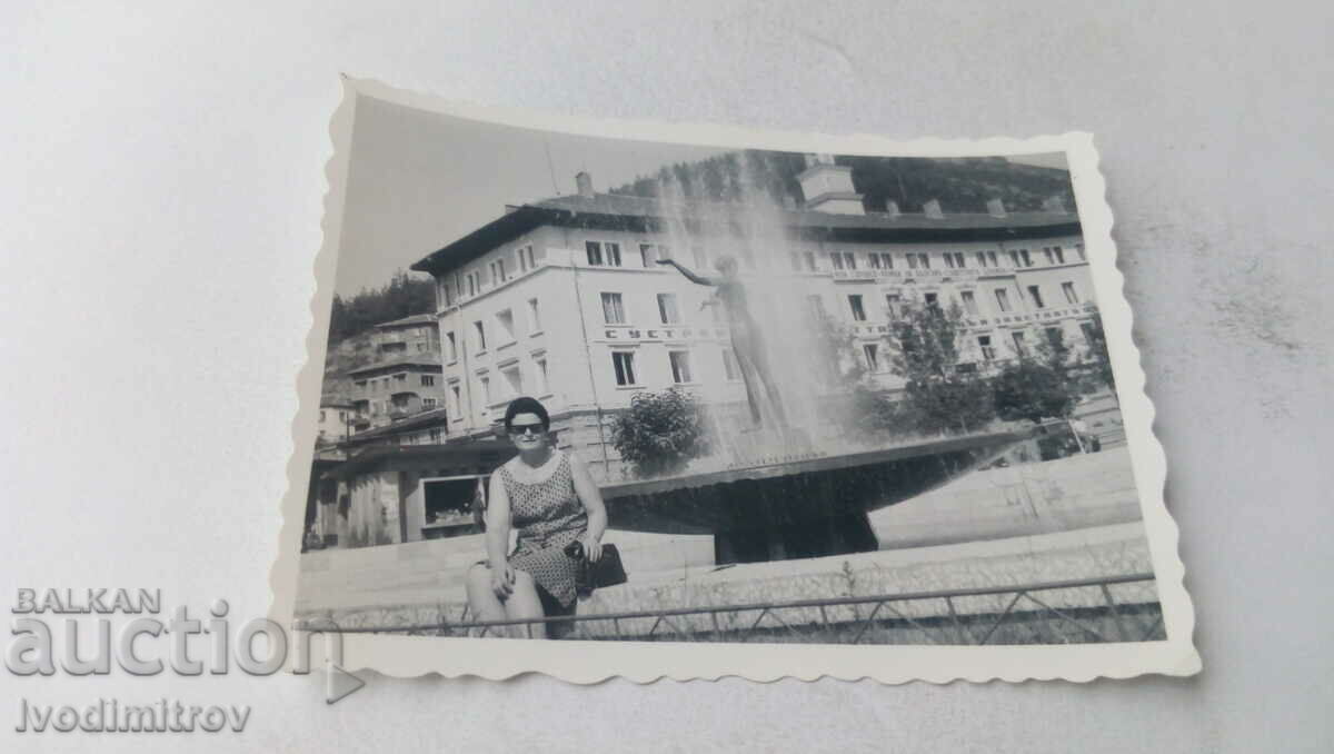 Photo Woman sitting by a fountain