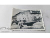 Photo Woman sitting by a fountain