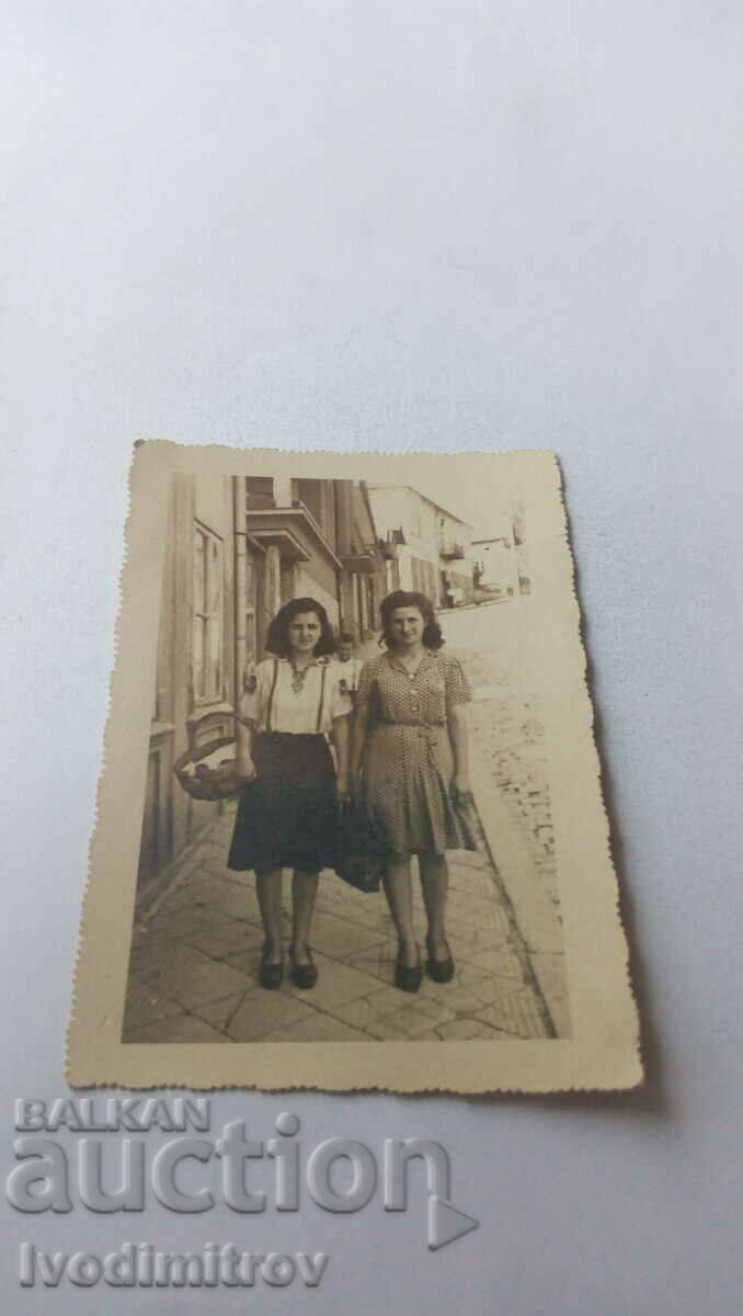Φωτογραφία Δύο νεαρές γυναίκες στο πεζοδρόμιο