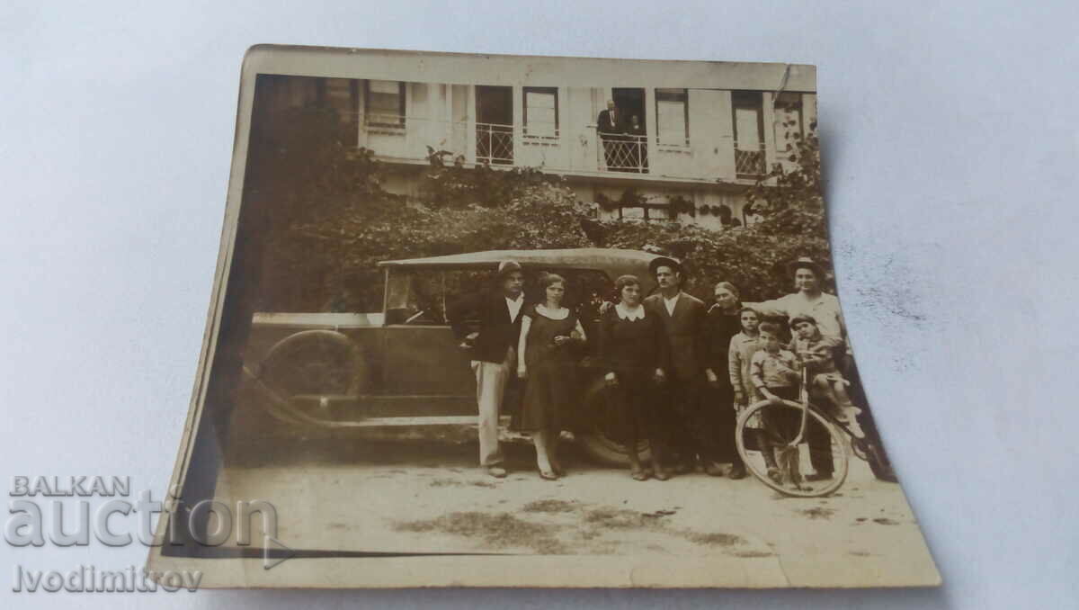 Fotografie Bărbați, femei și copii în fața unei mașini retro