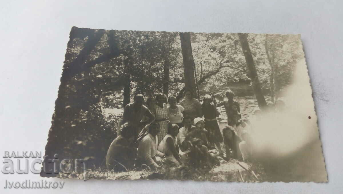 Photo Men women and children on a picnic in the woods