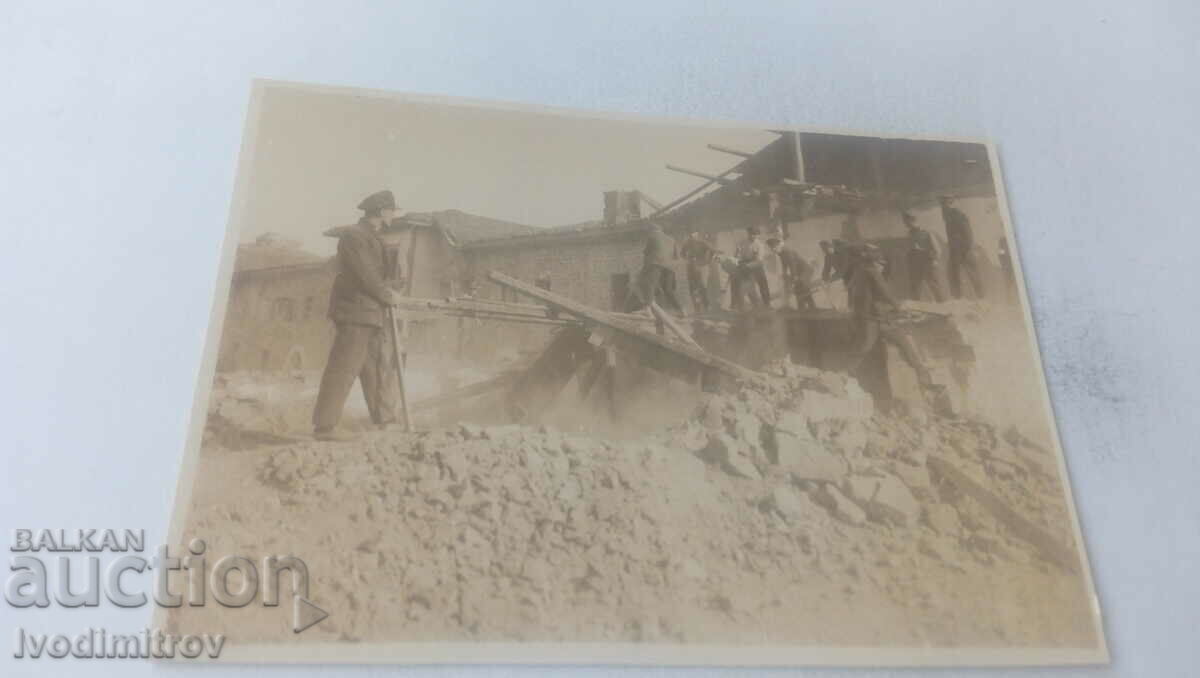 Photo Άνδρες κατεδαφίζουν ένα παλιό κτίριο