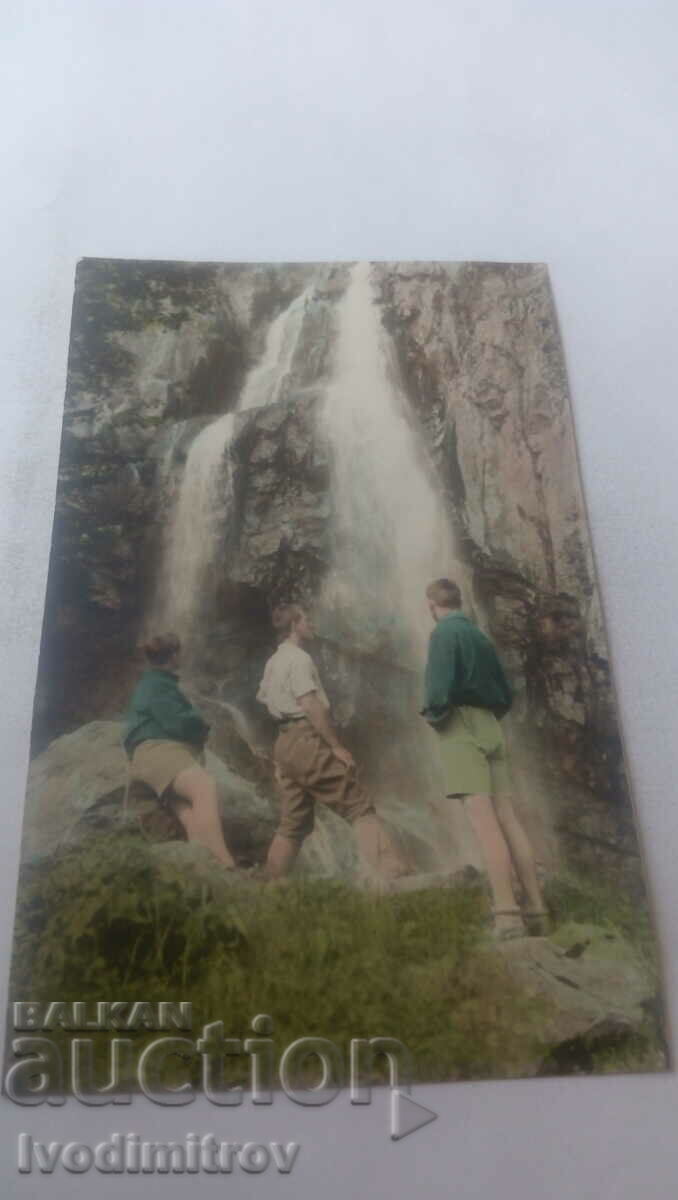 Photo Three young people in front of a waterfall