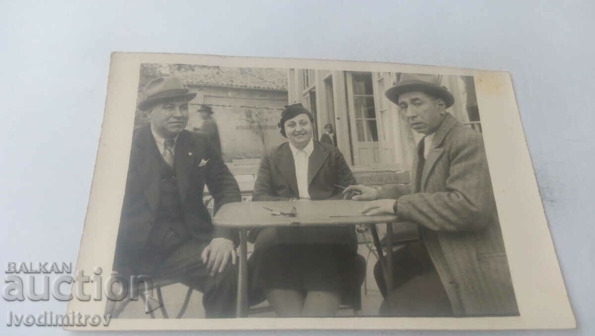 Photo Woman and two men at the table