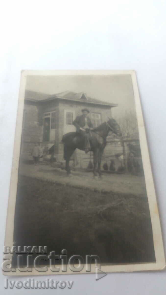 Photo Men on horseback in front of his house