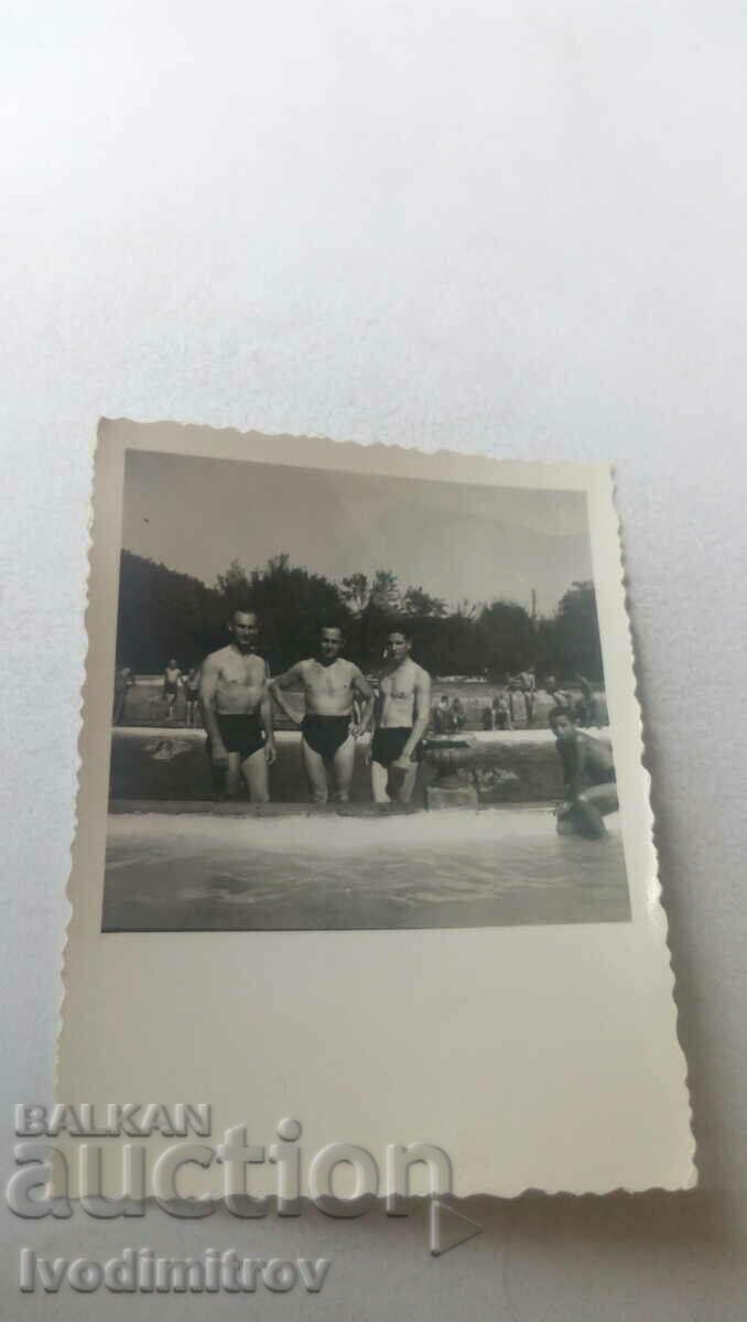 Foto Trei bărbați în costume de baie lângă piscină