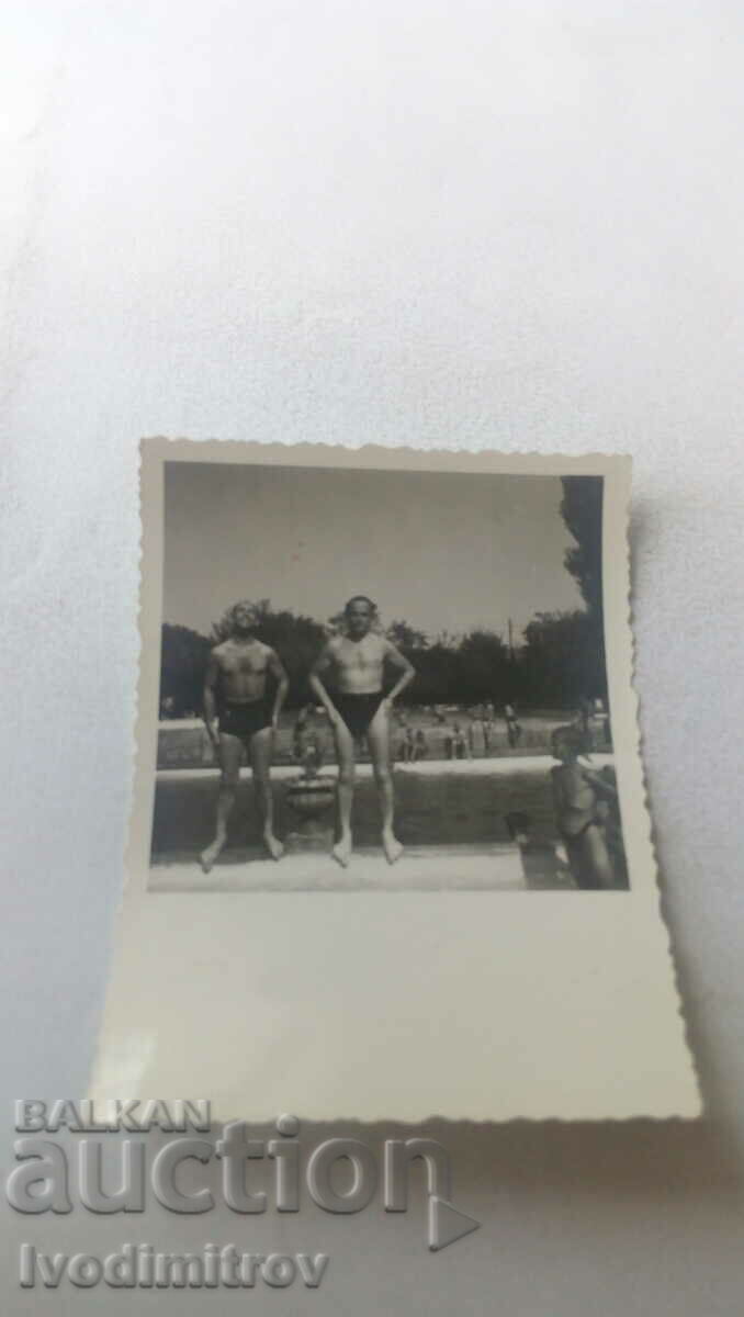 Foto Doi bărbați în costum de baie în fața piscinei