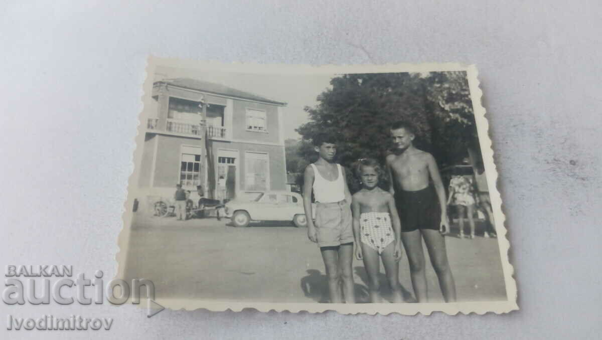 Photo Two boys and a boy in shorts on the square