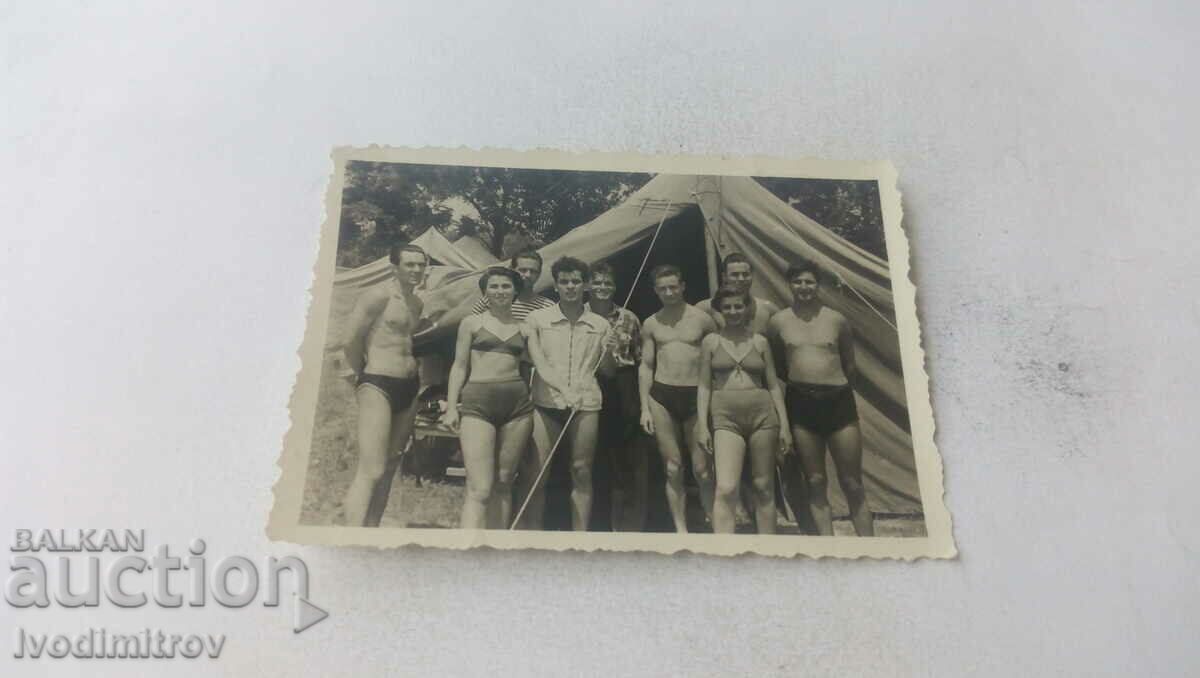 Fotografie Bărbați și femei în costume de baie în fața corturilor