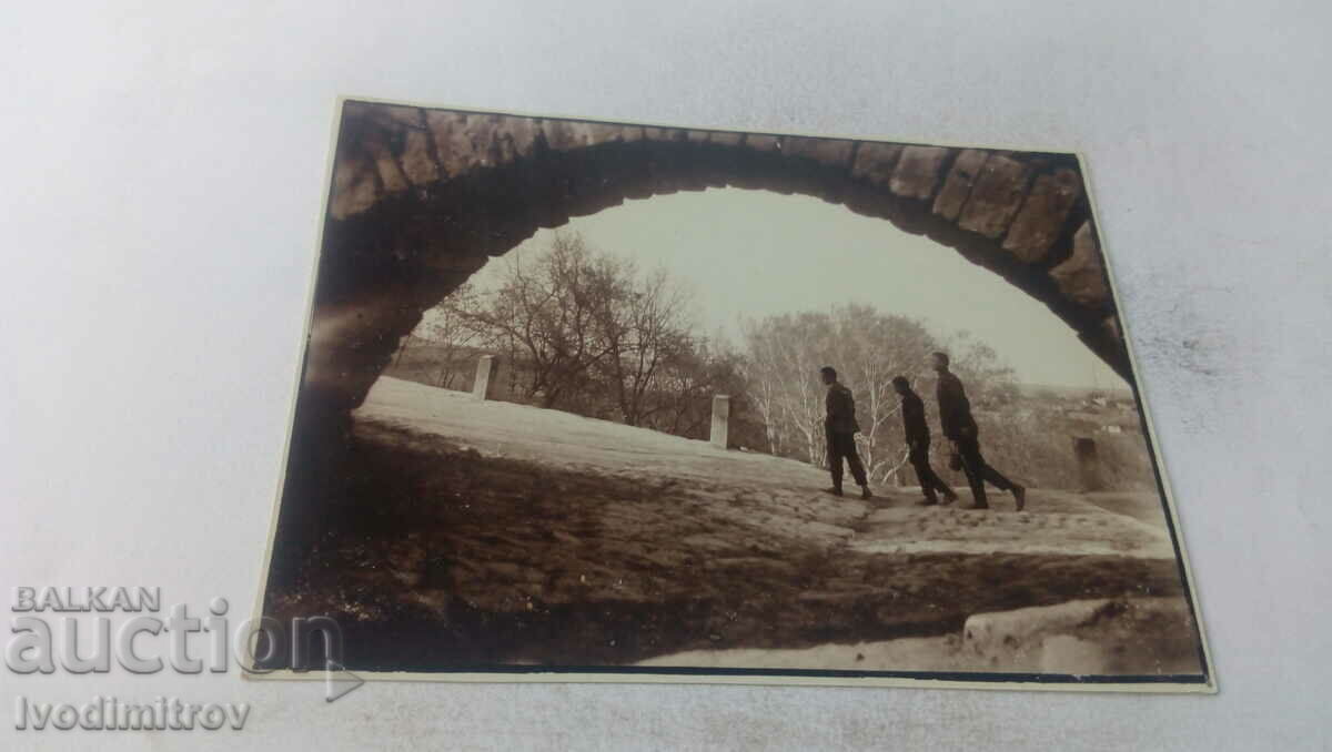 Fotografie Trei tineri lângă un arc de pod