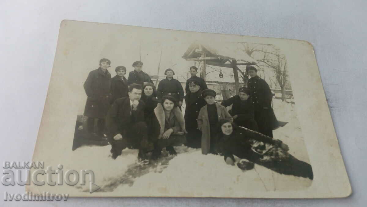 Photo Young men and women in front of a well in winter