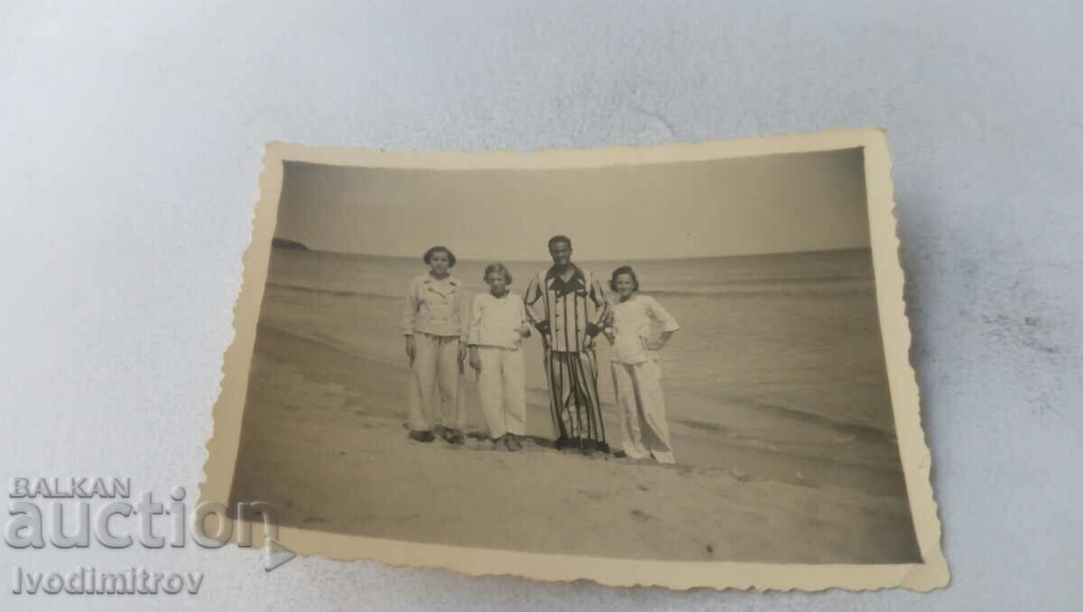 Photo A man and three women on the beach