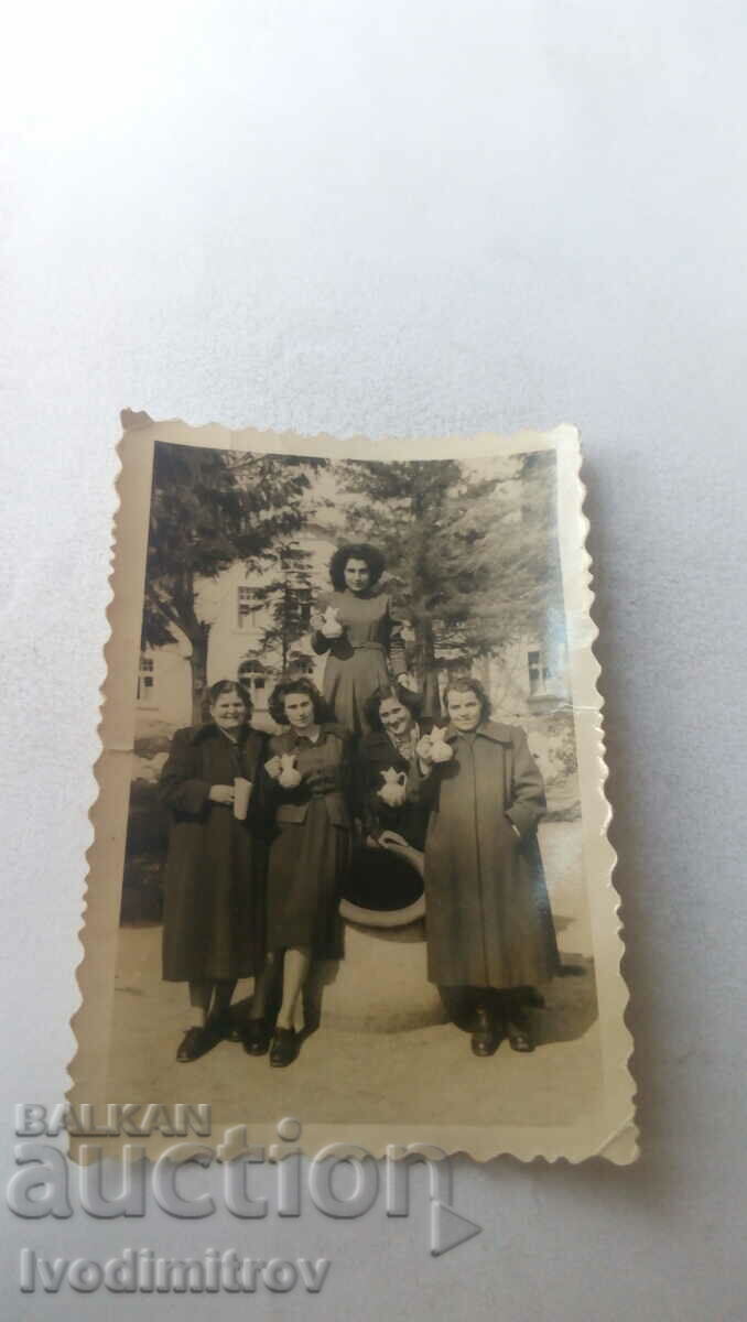 Imagine cinci femei în fața unui borcan