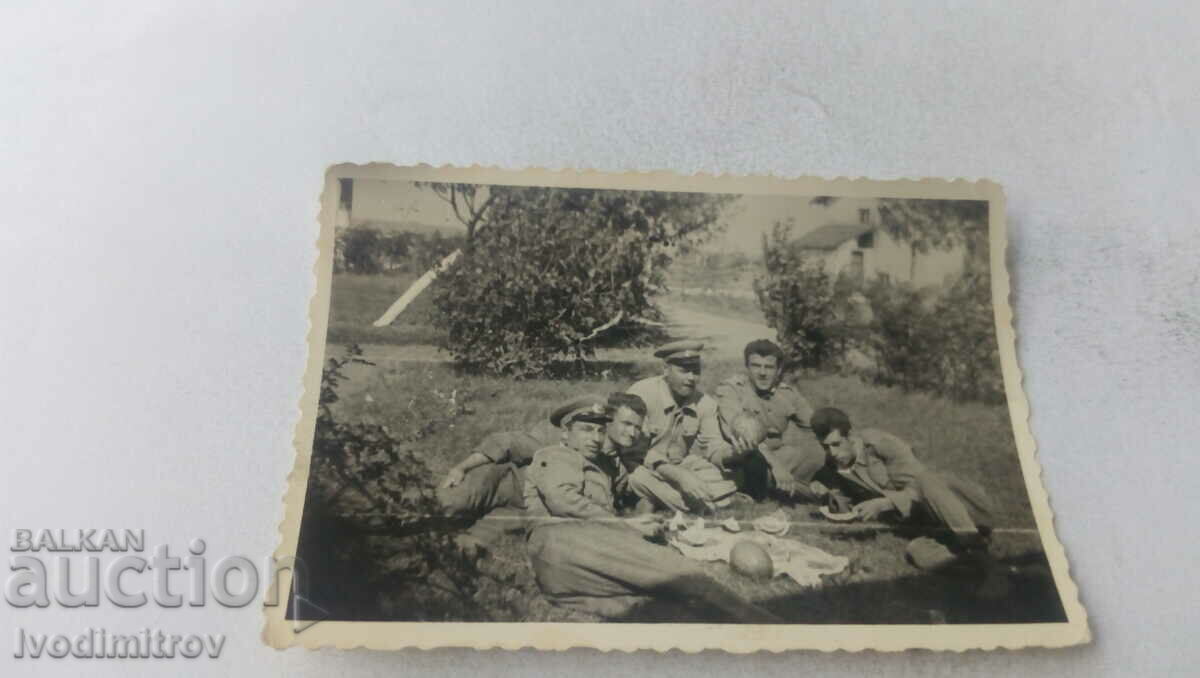 Photo Officers and soldiers eating watermelon in the meadow