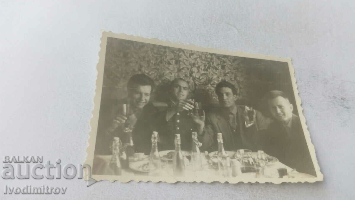 Φωτογραφία Ένας αξιωματικός και τρεις άνδρες που έχουν ένα ποτήρι κρασί