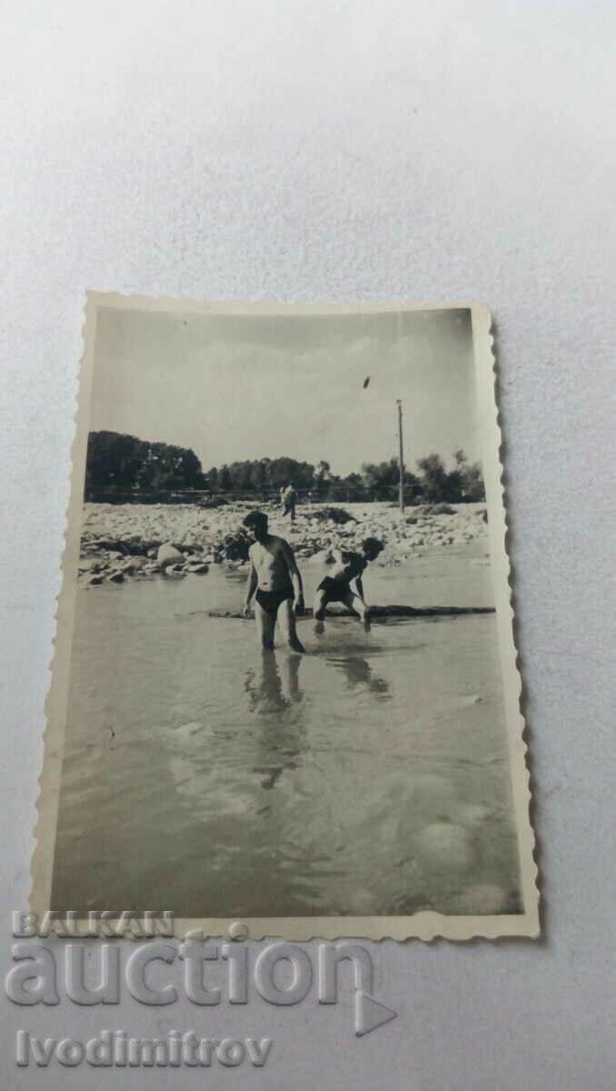 Fotografie Doi tineri în costume de baie în râu