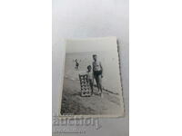 Снимка Мъж и момче с гумен дюшек на брега на морето