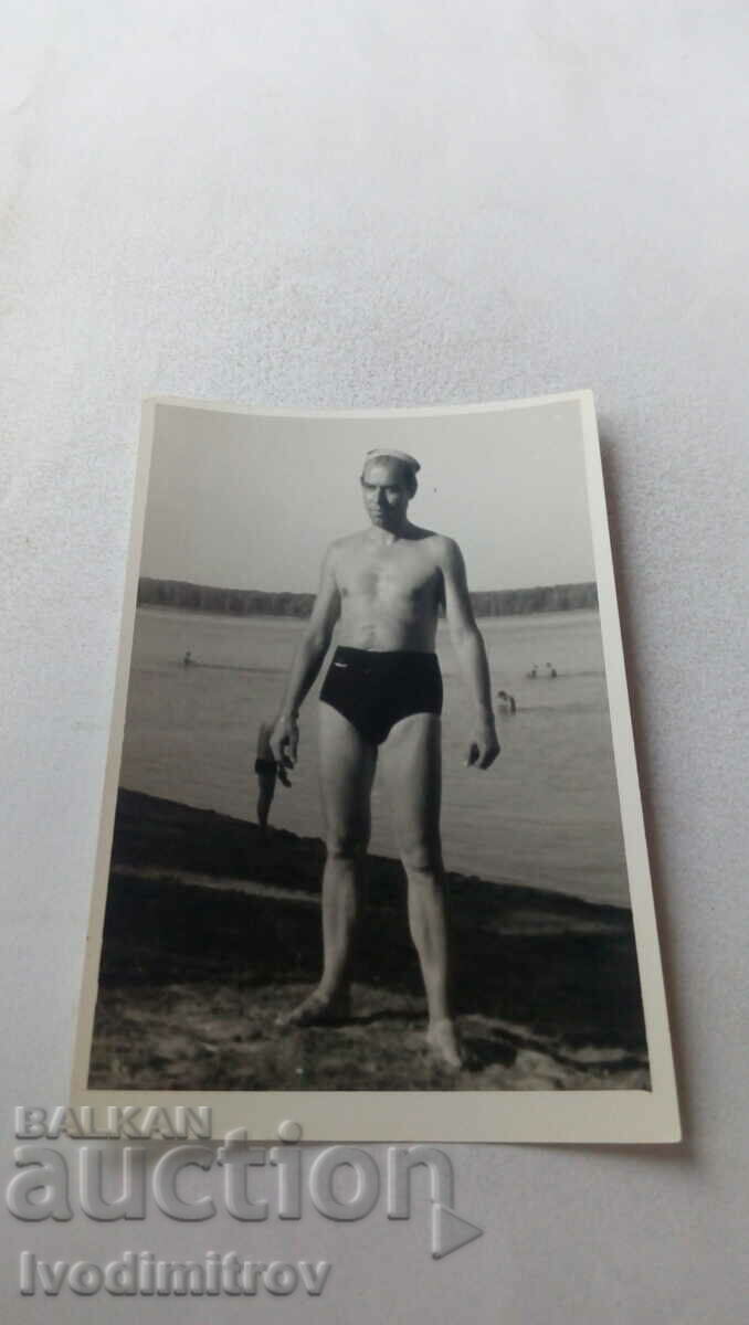 Photo A man in a swimsuit on the river bank