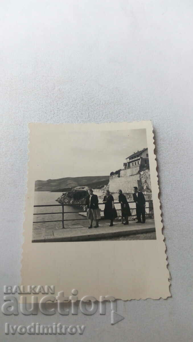 Φωτογραφία Ένας άνδρας και τρεις γυναίκες σε μια γέφυρα πάνω από τη θάλασσα