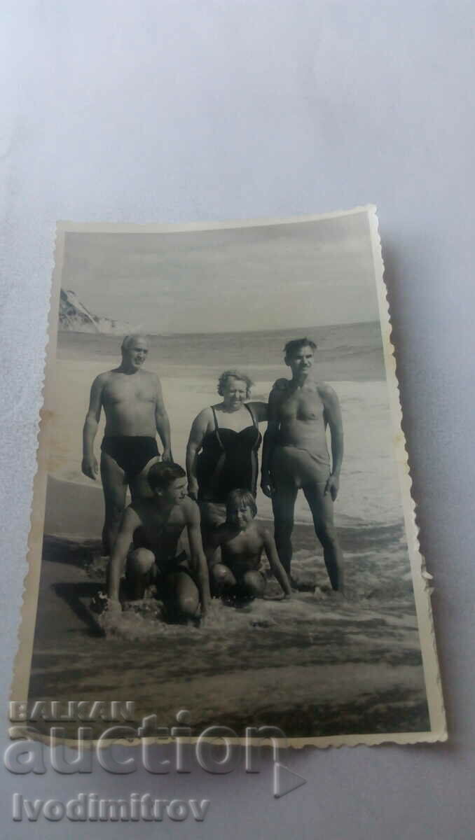 Foto Doi bărbați, o femeie și doi copii pe plajă