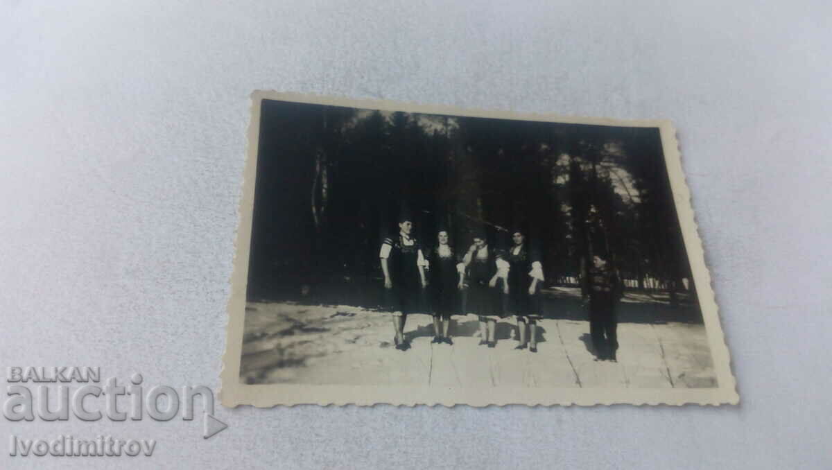 Foto Băiat și patru femei în costume populare iarna