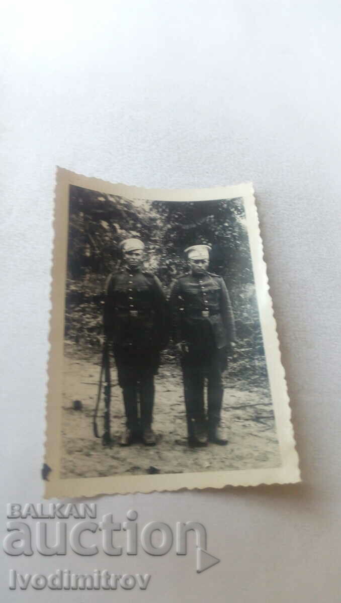 Φωτογραφία Δύο στρατιώτες με τα τουφέκια στα πόδια τους