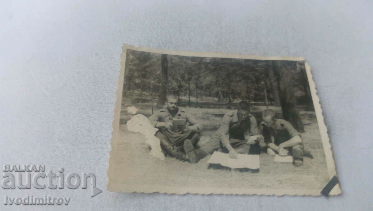 Φωτογραφία Τρεις στρατιώτες σπουδάζουν στο λιβάδι