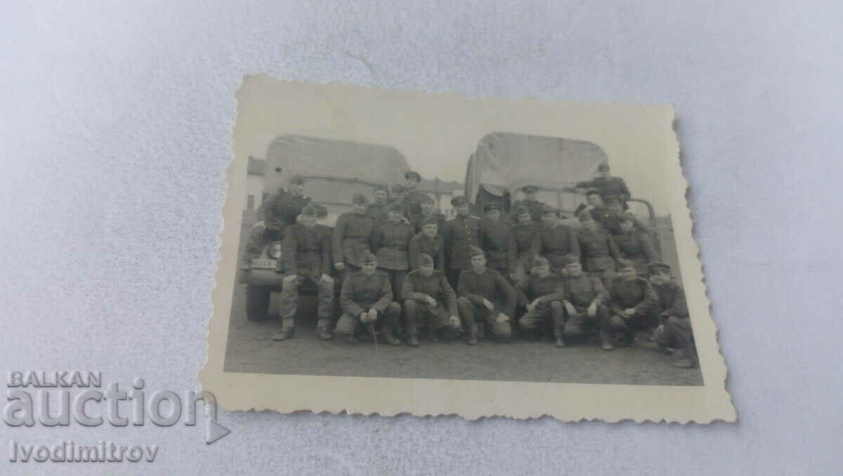 Foto Ofițer și soldați în fața a două camioane militare de epocă