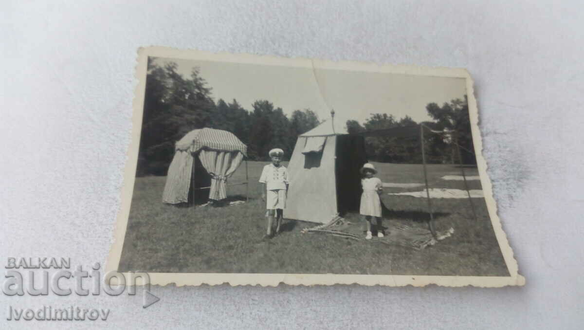 Photo Girl and moche in front of two tents