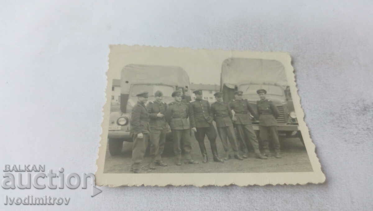 Photo Officer and soldiers in front of two vintage military trucks