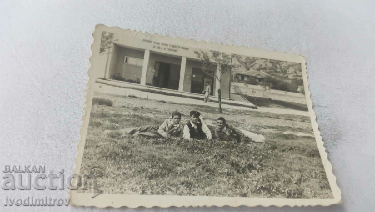 Photo Three young men lying on the grass