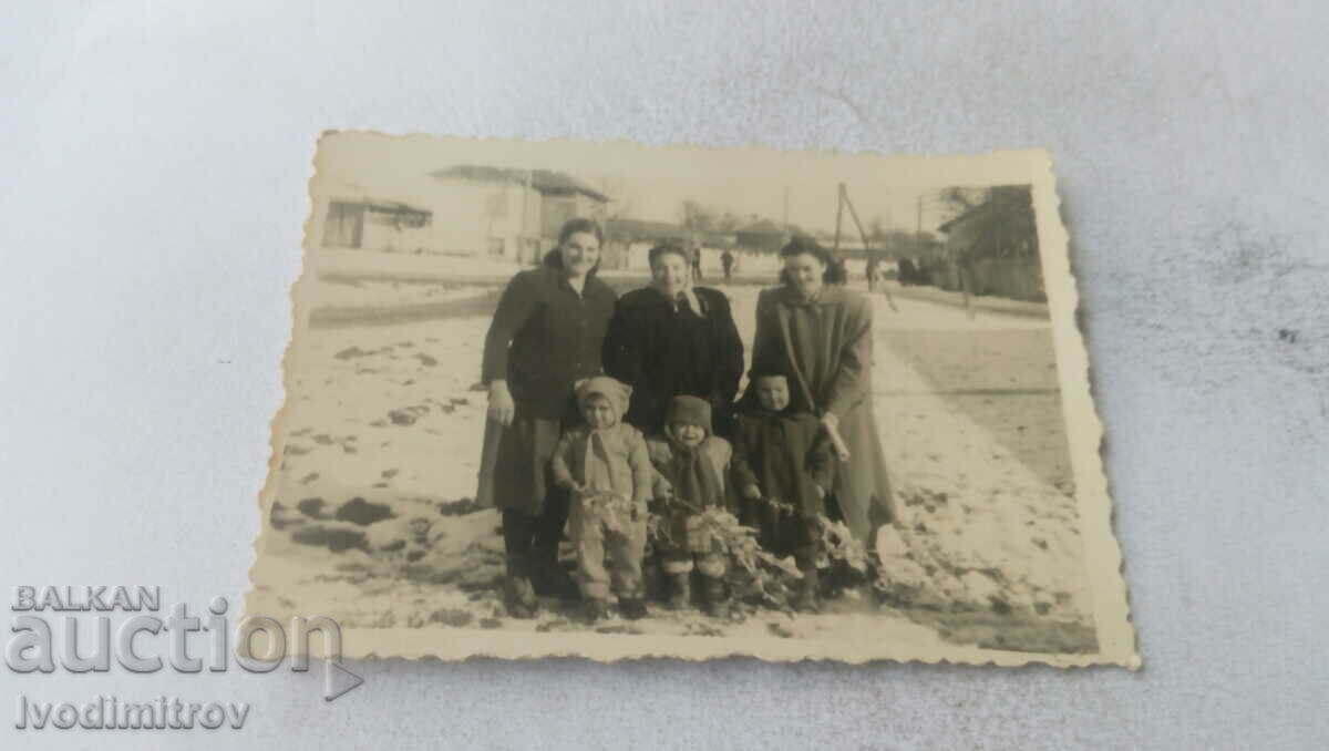 Foto Trei femei și trei copii pe stradă iarna