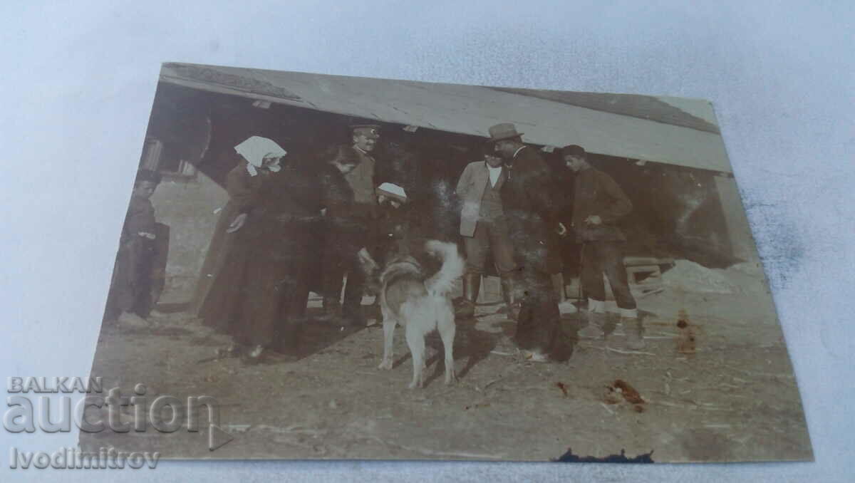 Photo Officer civilians and a dog in the yard