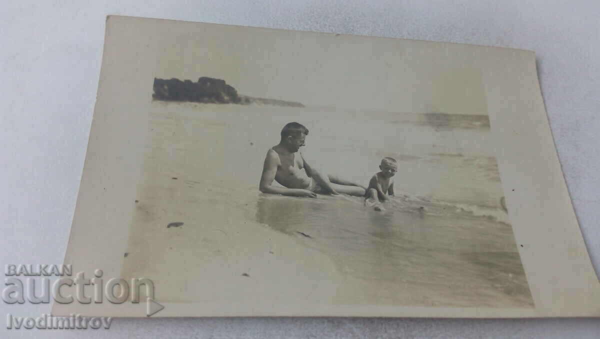 Снимка Мъж и мълко момченце на брега на морето