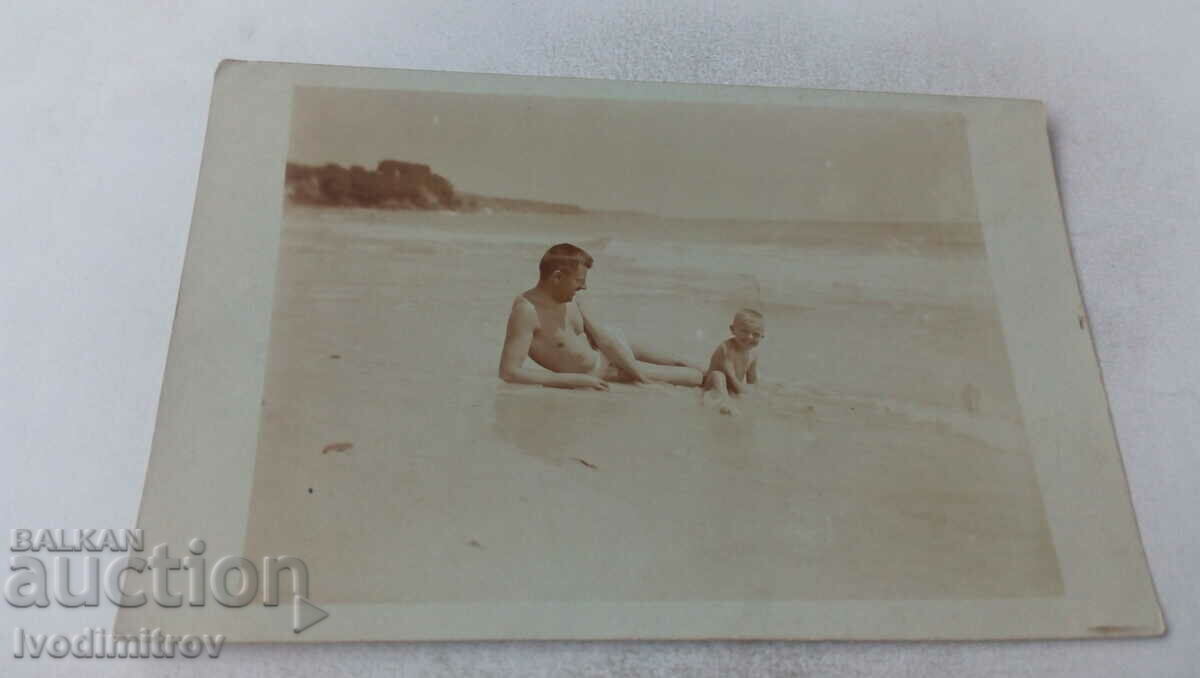 Снимка Мъж и мълко момченце на брега на морето
