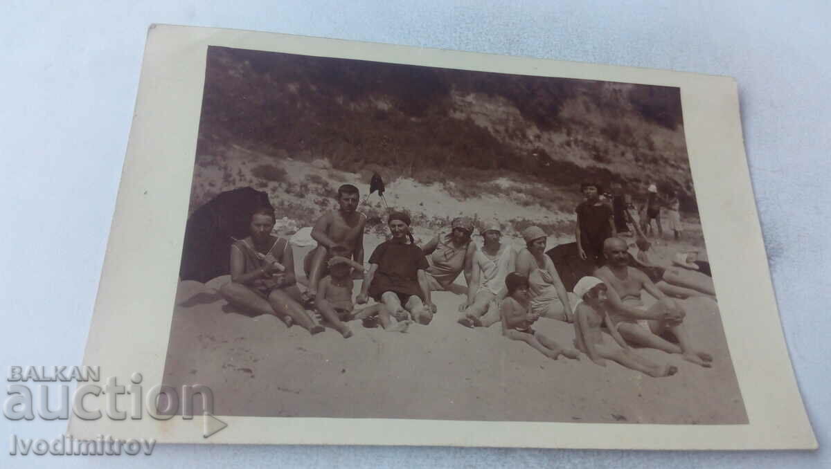 Foto Doi bărbați, femei și copii pe plajă