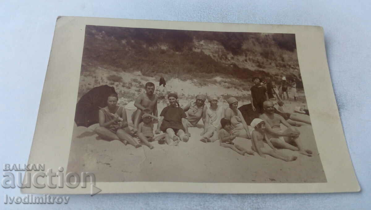 Foto Doi bărbați, femei și copii pe plajă